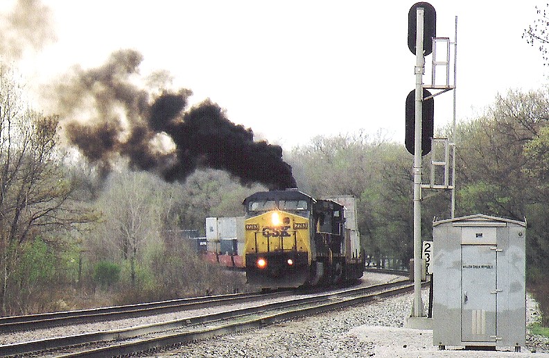 Smoke from CSX DASH8-40CW No. 7743 begins to fill into the air as the unit begins to proceed east with its train on CSX's Garrett Subdivision after waiting for a train to clear the diamond on CSX's Porter Branch at Willow Creek Junction in Portage, Indiana on April 20, 2002. Photo by J.R.V. at HS.
